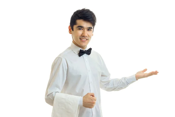 Encantador camarero alegre con camisa de pelo negro presta una mano de ayuda a un lado y sonriendo — Foto de Stock