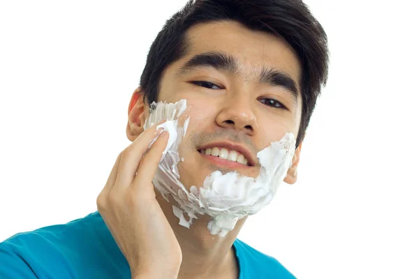 Retrato de un joven guapo que sonríe a la cámara y te afeita la cara con espuma. —  Fotos de Stock