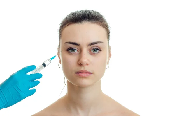 Косметолог делает инъекционный шприц на лице молодой красивой девушки, которая выглядит крупным планом — стоковое фото