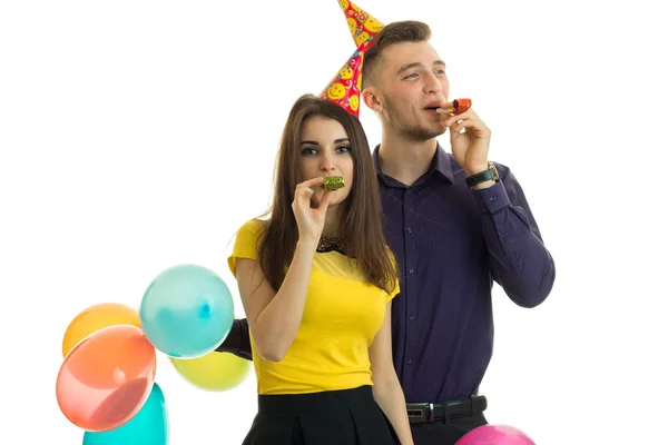 Docela sranda holka a chlap drží balónky a ránu rohy detail — Stock fotografie