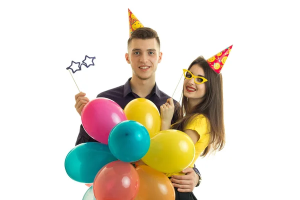 Chico guapo y linda chica en ropa elegante llevando una gran cantidad de globos y maniquíes de papel para cada cumpleaños —  Fotos de Stock