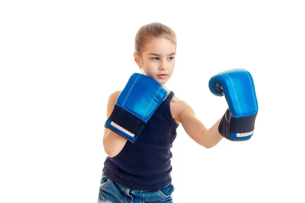 Niña de pie delante de la cámara en grandes guantes de boxeo está aislado sobre un fondo blanco — Foto de Stock