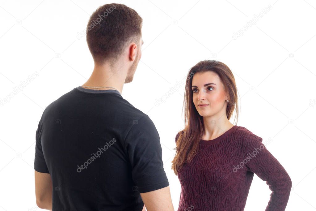 tall young guy in a black t-shirt stands opposite the girl and looks at her
