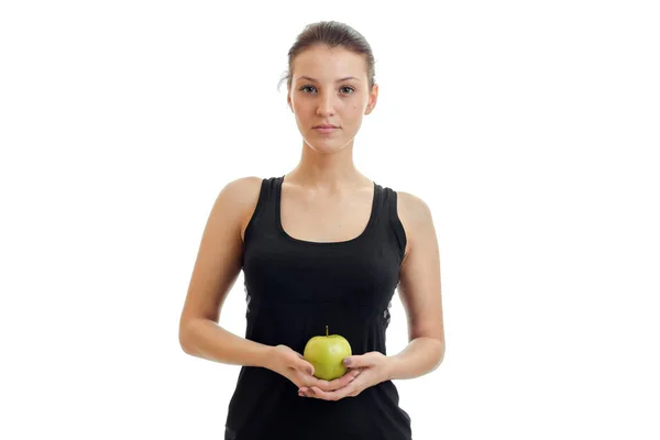 Linda chica joven en la camisa negra se ve recta y sosteniendo un primer plano de manzana verde — Foto de Stock