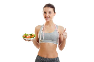 çekici bir genç kız bir el hareketi gösterir ve bir tabak marul tutar