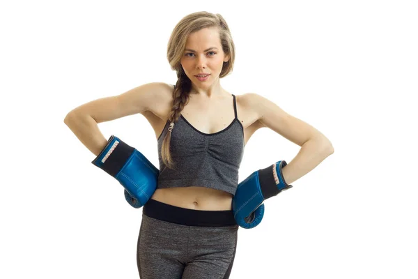 Sexy young athletic blonde looks straight and keeps hands on the sides in boxing gloves — Stock Photo, Image