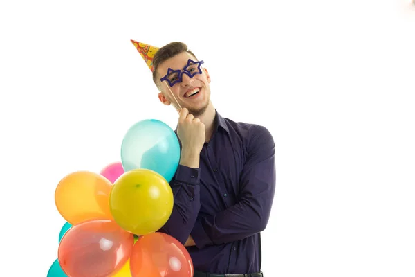 Grappige kerel met ballonnen in zijn handen en papier glazen lacht — Stockfoto