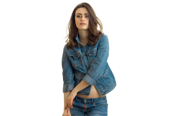 Jovem bela morena sorri e olha para a câmera em uma jaqueta de jeans close-up — Fotografia de Stock