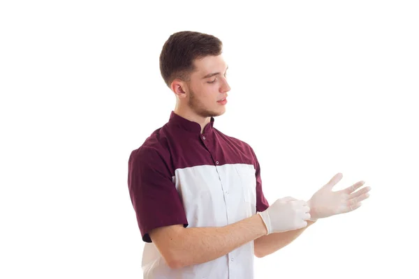 Eine junge Laborantin legt die Hände auf weiße Handschuhe in Großaufnahme — Stockfoto