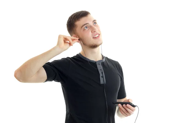 Young lovely guy looks up smiling and listening to music with headphones — Stock Photo, Image