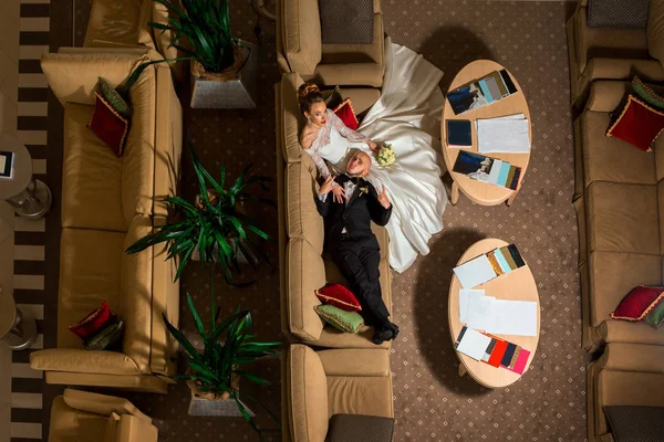 Funny young just merried couple lying on a sofa — Stock Photo, Image