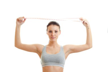 güzel spor kız baş üzerinde ölçüm bandı tutar.