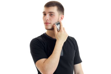 Genç sevimli adam kafasını tarafa döndü ve tıraş sakal düzeltici