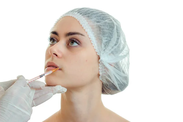 Kosmetolog gör en prick på läpparna av en ung vacker flicka närbild — Stockfoto