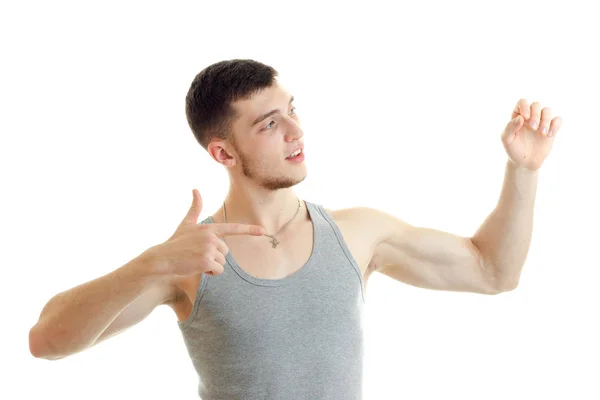 Handsome young guy in the t-shirt looks away and shows hands gestures — Stock Photo, Image