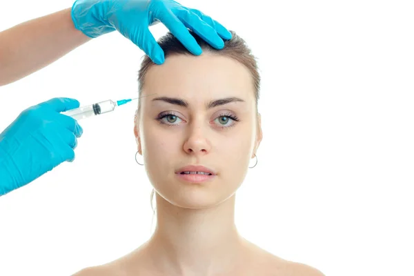 El médico inyecta la vacuna en la frente a las niñas jóvenes sin maquillaje de cerca —  Fotos de Stock