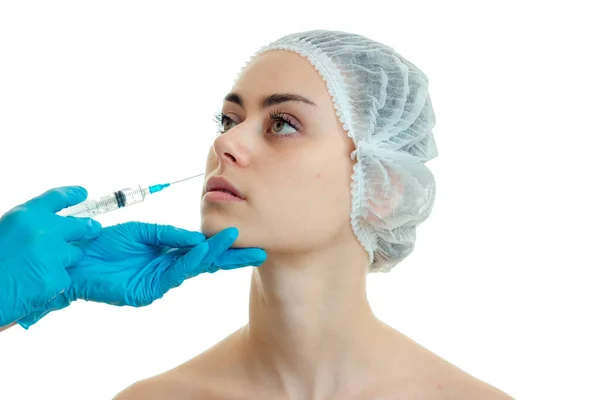 Косметолог вводит вакцину против морщин на лице молодой девушки в специальном кепке крупным планом — стоковое фото
