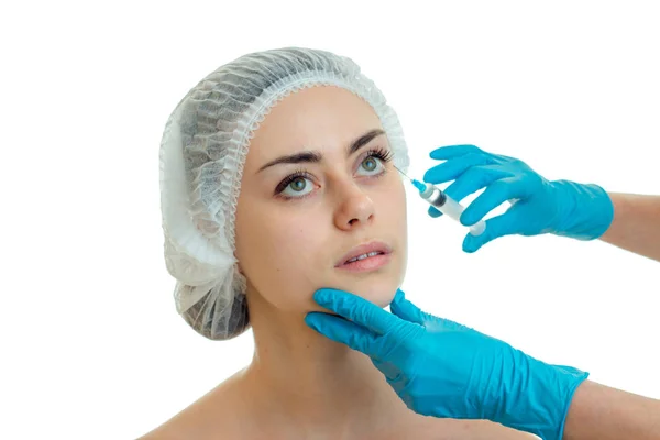 Médico en guantes azules hace una inyección analgésica en la cara de una niña de cerca —  Fotos de Stock