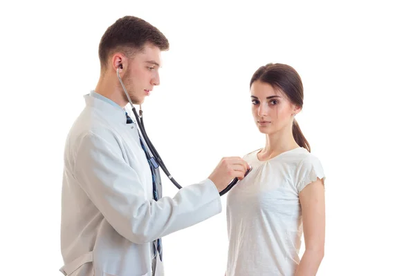Доктор в белом халате у своих пациентов сердце слушает стетоскоп крупным планом — стоковое фото