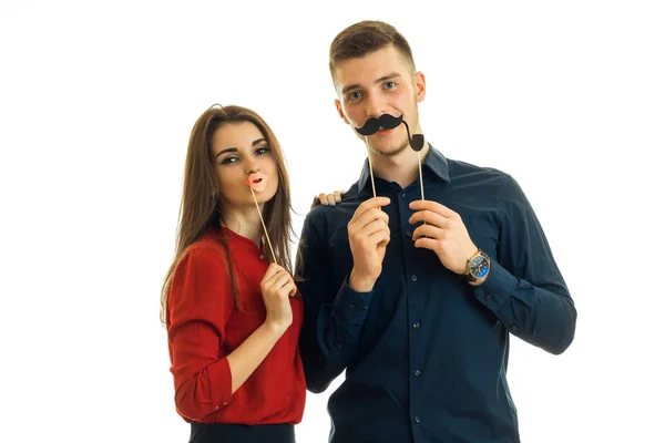 Beautiful girl and a young guy hold near face paper Dummies for photo and looking at camera — Stock Photo, Image