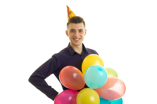 Jolly συμπαθητικός τύπος φαίνεται στην κάμερα και κρατά στο χέρι του πολλά πολύχρωμα μπαλόνια — Φωτογραφία Αρχείου