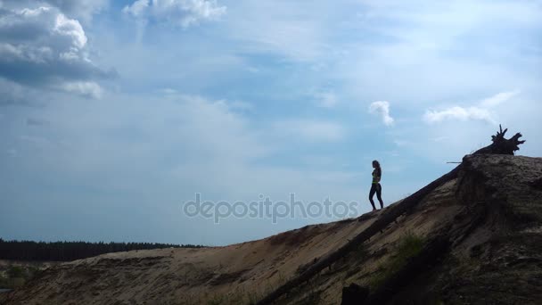 Een sportieve jongedame wandelingen op de top van de heuvel — Stockvideo