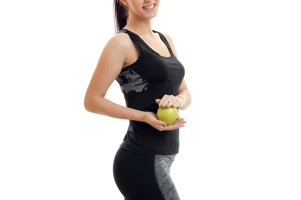 Slim young girl stands sideways and holding a Green Apple close-up — Stock Photo, Image