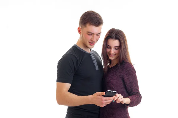 Красивые молодые парень и девушка улыбаются и смотрят фотографии в моем телефоне — стоковое фото