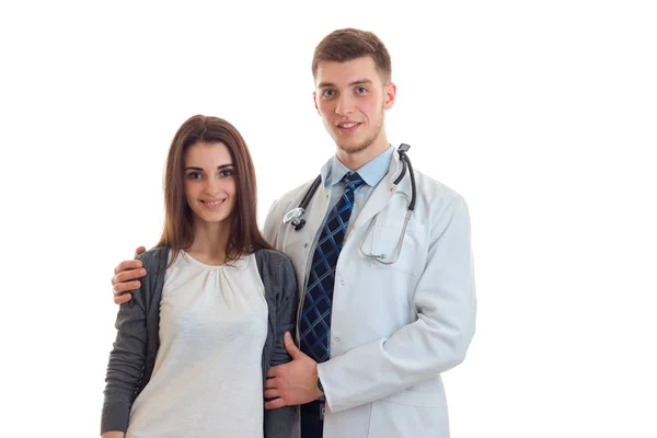 Un joven médico bata sonríe y mantiene los hombros una hermosa chica feliz —  Fotos de Stock