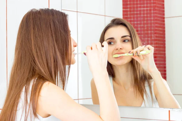 En ung kvinna borsta tänderna — Stockfoto