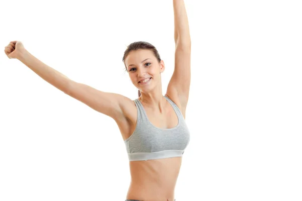 Cheerful sports girl smiling on camera with hands up in the air — Stock Photo, Image