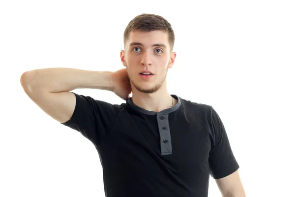 Überraschter junger Mann im schwarzen T-Shirt schaut im Studio weg — Stockfoto