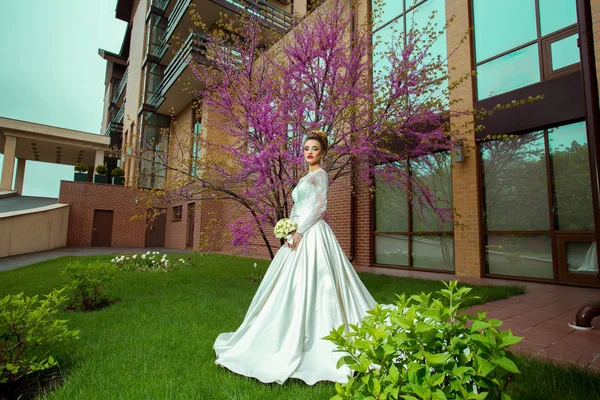 Glamour junge blonde Braut posiert mit Sacura-Baum — Stockfoto