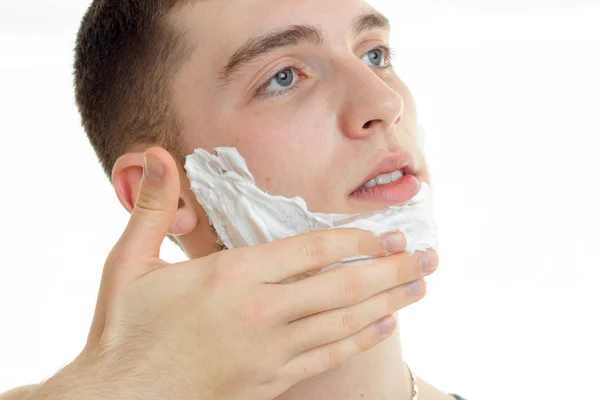 Primer plano retrato de joven guapo hombre con crema de afeitar en su cara —  Fotos de Stock