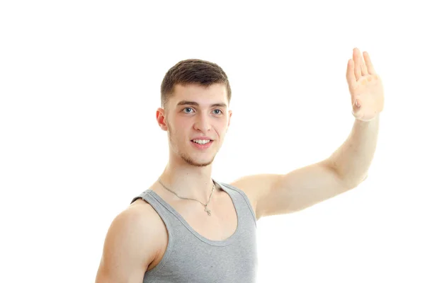 Kecke junge Kerl winkt mit der Hand und schaut weg — Stockfoto