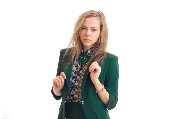 Ernstige blonde zakenvrouw in groene uniforme kijken naar de camera — Stockfoto