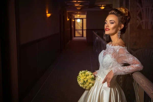 Fiatal szőke menyasszony menyasszonyi ruha rózsákkal a kezében — Stock Fotó