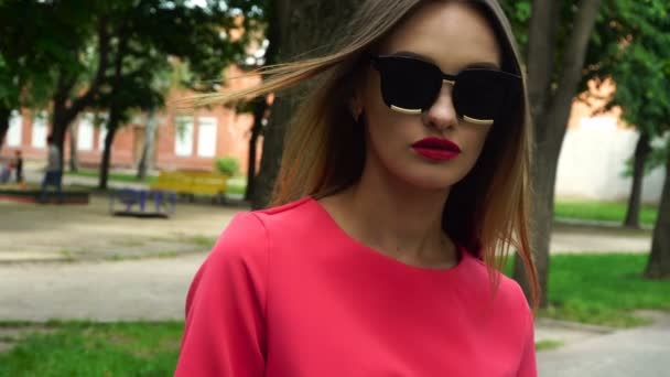 Adorable rubia en gafas de sol y traje rojo al aire libre — Vídeos de Stock
