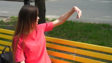 Kırmızı elbiseli bir kadın selfie Park'ta yapar.