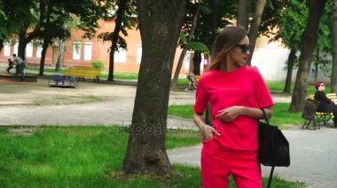 Kırmızı takım elbise ve güneş gözlüğü parkta şık seksi kız