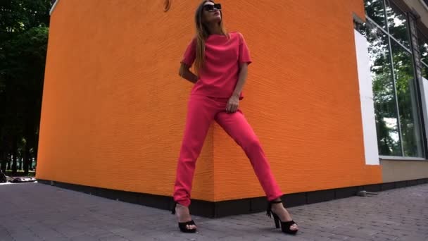 Сексуальная молодая модель моды на высоких каблуках в красном костюме позирует — стоковое видео