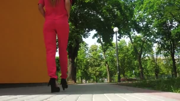 ハイヒールと赤いスーツの美しいビジネス女性がダウ通りを歩く — ストック動画