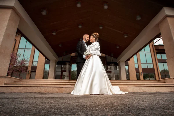 Junges Ehepaar im wunderschönen Hochzeitsanzug umarmt — Stockfoto