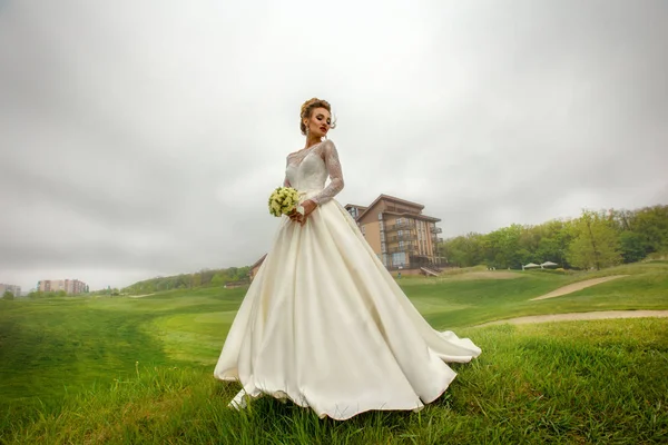 Glamour junge Braut in wunderschönem Brautkleid posiert im Freien — Stockfoto