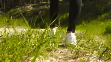 beyaz spor ayakkabı kız yaz aylarında kum ve çim üzerinde yürüyor