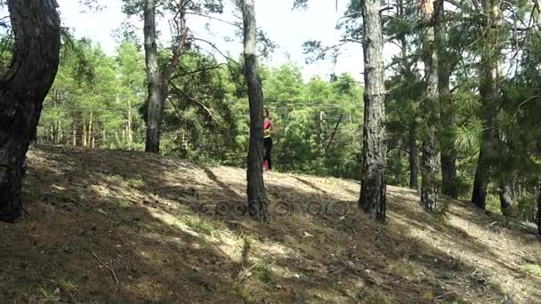 Chraming fille en uniforme de sport courir autour de la forêt — Video