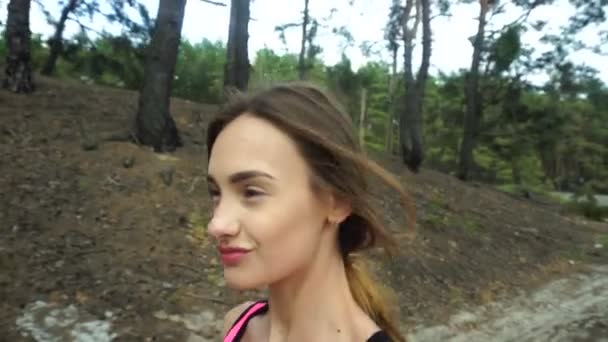Молодая веселая девушка гуляет по лесу — стоковое видео