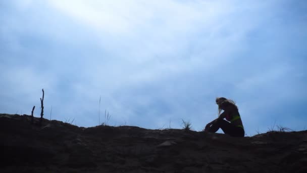 Silhouette eines jungen athletischen Mädchens auf einem Sandhügel — Stockvideo