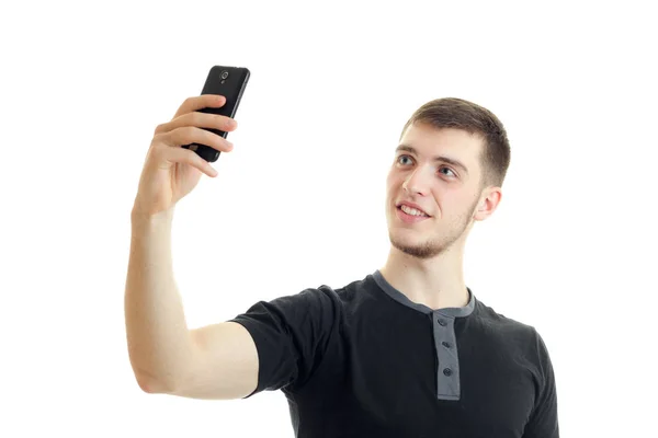 Um close-up retrato de jovem sorrindo cara em uma camiseta que faz foto no telefone — Fotografia de Stock