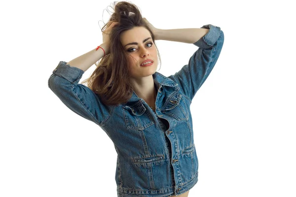 Bella ragazza sorridente in piedi in giacca jeans e mantiene i capelli mani — Foto Stock